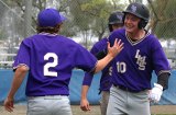 Lemoore's Jared Holaday is greeted in the dugout by Teddy Weber after scoring to tie the game in the seventh inning.